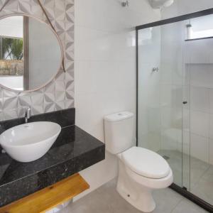La salle de bains est pourvue de toilettes, d'un lavabo et d'un miroir. dans l'établissement Camboa Village, à Barra Grande