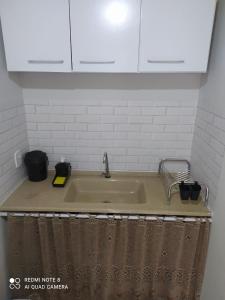 a kitchen counter with a sink and white cabinets at APARTAMENTO DU VÔ in Santa Teresa