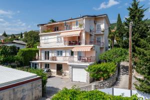 an apartment building with balconies and a garage at Apartments Melita in Crikvenica