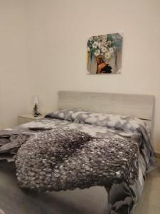 1 dormitorio con 1 cama y una pintura en la pared en CASA RED ROSE, en Maddaloni