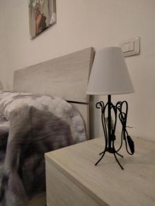 una lámpara sentada en una mesa junto a una cama en CASA RED ROSE, en Maddaloni
