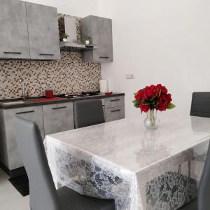 una cocina con una mesa con un jarrón de flores. en CASA RED ROSE, en Maddaloni