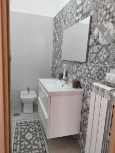 y baño con lavabo, espejo y aseo. en CASA RED ROSE, en Maddaloni