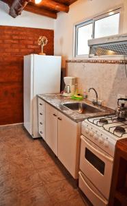 a kitchen with a white refrigerator and a sink at Cabañas Cascada Escondida in El Bolsón