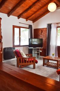 a living room with a couch and a flat screen tv at Cabañas Cascada Escondida in El Bolsón