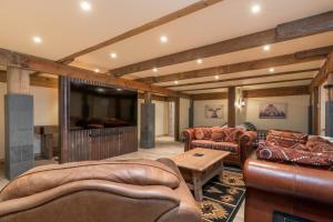 sala de estar con muebles de cuero y TV de pantalla plana en Bear Lodge with private Pool, Hottub, and Sauna!, en Hailey