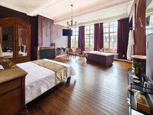 ein großes Schlafzimmer mit einem Bett und einer Badewanne in der Unterkunft Hotel Restaurant Steenhuyse in Oudenaarde