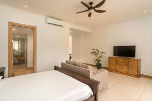 Schlafzimmer mit einem Bett und einem Flachbild-TV in der Unterkunft Royale Suites by Arc Royal Luxury Apts in Anse Royale