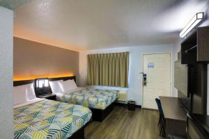 a hotel room with two beds and a desk at Motel 6-Sacramento, CA - Old Sacramento North in Sacramento