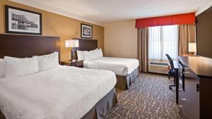a hotel room with two beds and a desk at Best Western Plus Peoria in Peoria
