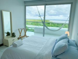 um quarto com uma cama e uma grande janela em Apartamento Cartagena en Morros frente a la playa em Cartagena das Índias