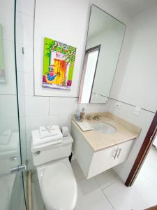 a bathroom with a toilet and a sink and a mirror at Apartamento Cartagena en Morros frente a la playa in Cartagena de Indias
