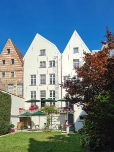 een groot wit appartementencomplex met een tuin bij Hotel Restaurant Steenhuyse in Oudenaarde