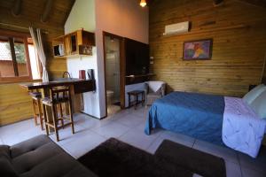 a bedroom with a bed and a kitchen and a table at Pousada Village dos Canyons in Praia Grande