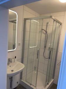 ein Bad mit einer Dusche und einem Waschbecken in der Unterkunft Weseler Wirtshaus Appartements in Wesel
