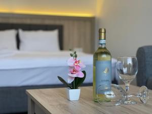eine Flasche Wein und eine Blume auf dem Tisch in der Unterkunft Weseler Wirtshaus Appartements in Wesel