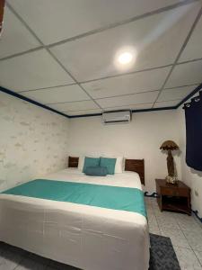 um quarto com uma cama grande num quarto em Olas Permanentes El Zonte em El Zonte