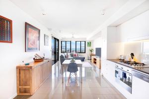 a kitchen and living room with a table and a couch at Darwin Waterfront Lagoon Hideaway with Sea Views in Darwin