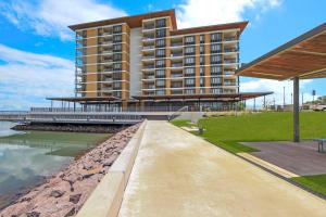 a building with a walkway next to a body of water at Darwin Waterfront Lagoon Hideaway with Sea Views in Darwin