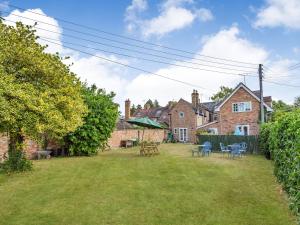 een tuin met tafels en stoelen voor een huis bij Wards Court 2 in Gloucester