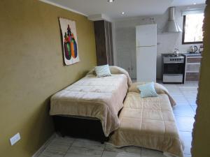 a bedroom with two beds and a kitchen at Molar-Hue in Villa Pehuenia