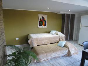 um quarto de hotel com duas camas e um sofá em Molar-Hue em Villa Pehuenia