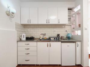 a white kitchen with white cabinets and a sink at Ada Belgrade Apartment in Belgrade