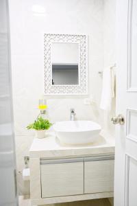 a white bathroom with a sink and a mirror at EL BORSALINO - Apartamento en Amazonas, Leticia in Leticia