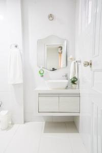 a white bathroom with a sink and a mirror at EL BORSALINO - Apartamento en Amazonas, Leticia in Leticia
