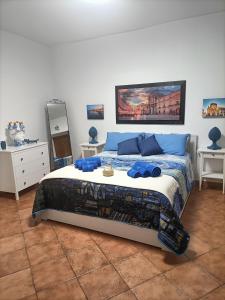- une chambre avec un lit doté d'oreillers bleus dans l'établissement La casetta di Diana Ortigia, à Syracuse