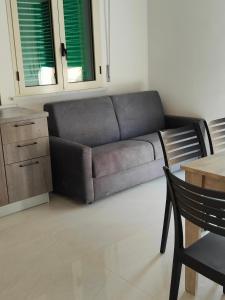 een woonkamer met een bank en een tafel bij Fantasia BeB APARTAMENT STUDIO in Pellaro