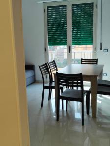 a dining room with a table and chairs and a window at Fantasia BeB APARTAMENT STUDIO in Pellaro