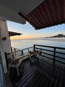 a deck with a table and a view of the ocean at Casa Marambaia 3 in Rio de Janeiro