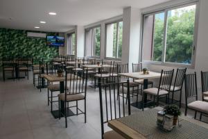 a dining room with tables and chairs and windows at The Park Hotel in Guayaquil