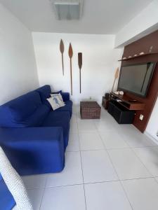 sala de estar con sofá azul y TV en Casa Marambaia 3, en Río de Janeiro