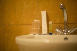 a bathroom sink with a faucet and a soap dispenser on it at Al Nakhlah Serviced Apartments 1 in Al Hofuf +6 photos