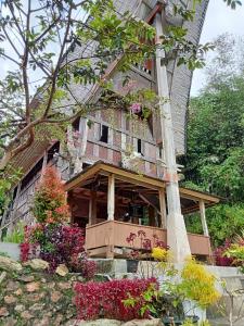 an old house with flowers in front of it at NUANSA HOMESTAY Authentic&Hospitality in Rantepao