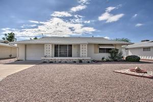 a house with a gravel driveway in front of it at Golf Course and Pool Access Quaint Sun City Home in Sun City
