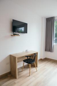 a desk with a tv and a chair in a room at The Park Hotel in Guayaquil