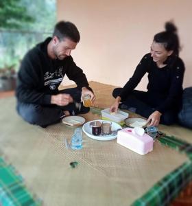 a man and woman sitting on the floor eating food at NUANSA HOMESTAY Authentic&Hospitality in Rantepao +118 photos
