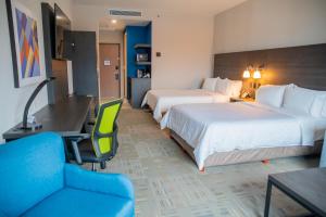 Holiday Inn Express & Suites - Tijuana Otay, an IHG Hotel في تيخوانا: غرفة فندقية بسريرين ومكتب