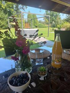a table with a bottle of soda and a bowl of blueberries at Dom Pod Gaikiem in Łękawica