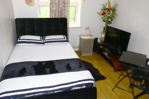 ロンドンにあるCentral London roomsのベッドルーム(白黒のベッド1台、テレビ付)