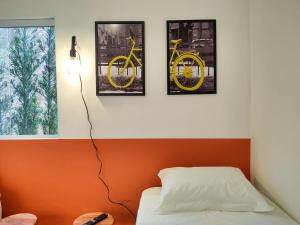 a bedroom with three pictures of a yellow bike on the wall at Casas no centro com o sossego da roça - Hospedado por Casa de Tijolinho in Cunha
