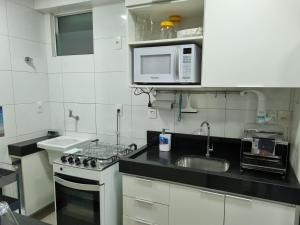 a kitchen with a sink and a microwave at EXCELENTE FLAT 2 QUARTOS no BESSA in João Pessoa