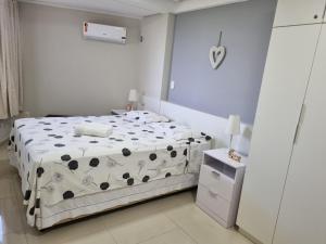 a bedroom with a bed with a black and white blanket at EXCELENTE FLAT 2 QUARTOS no BESSA in João Pessoa