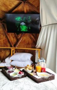 una mesa con dos bandejas de comida en una cama en Domo do Matto, en Garanhuns