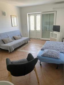 a living room with a couch and a chair at Apartments by the sea Dramalj, Crikvenica - 5596 in Dramalj