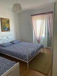 a bedroom with two beds and a window at Apartments by the sea Dramalj, Crikvenica - 5596 in Dramalj