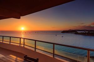 a view of the ocean at sunset from a balcony at Casa Del Sole Apartments in Noumea